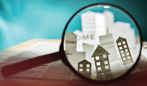 A magnifying glass magnifying buildings in a newspaper