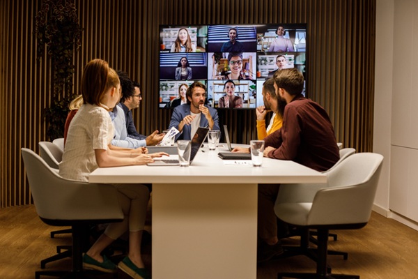 Hybrid office environment, meeting with in-person and remote workers.